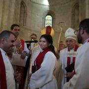 Sally Azar, centre, is applauded by clergy after being ordained in the Old City of Jerusalem