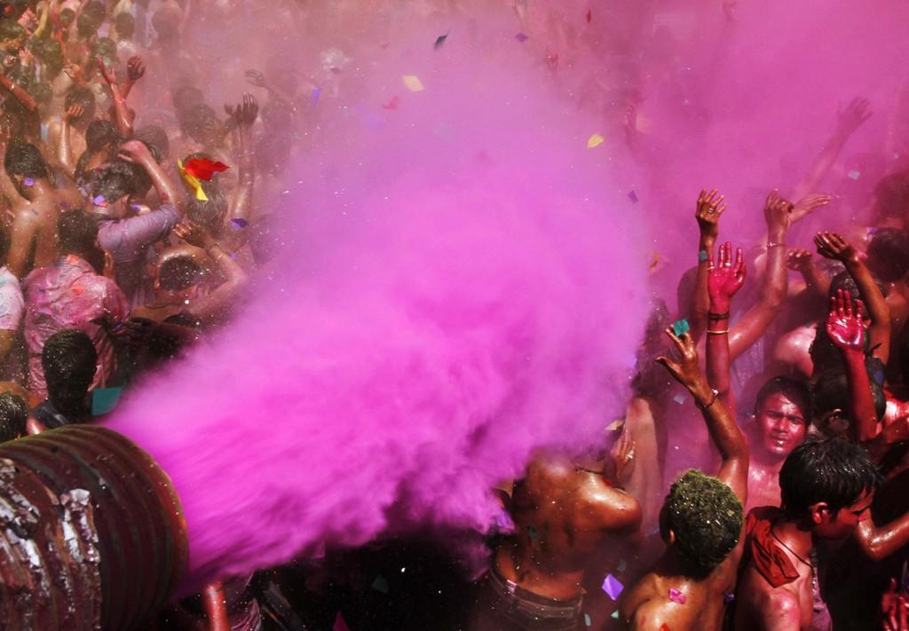 Colored dye is thrown as people dance during Holi celebrations in Allahabad, India, Friday, March 9, 2012.