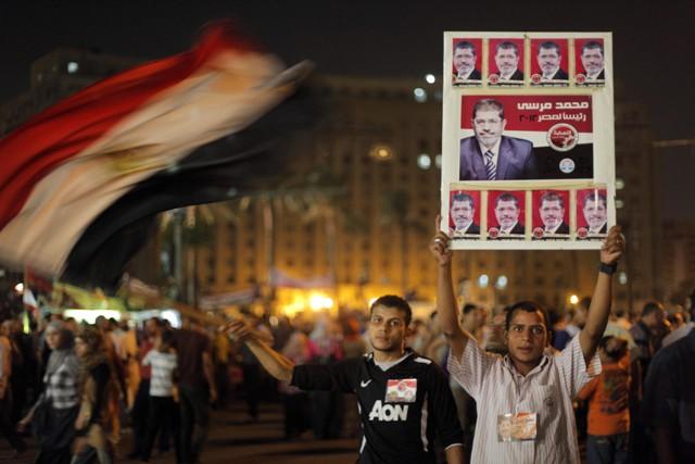 Supporters of Egypt's Islamist President Mohammed Morsi raise his poster and wave a national flag in Tahrir Square, birthplace of the uprising that ousted Hosni Mubarak 18 months ago.