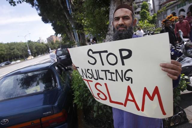 A Muslim expatriate holds a banner in protest of a film ridiculing Islam's Prophet Muhammad after prayers at the main mosque in Taipei, Taiwan