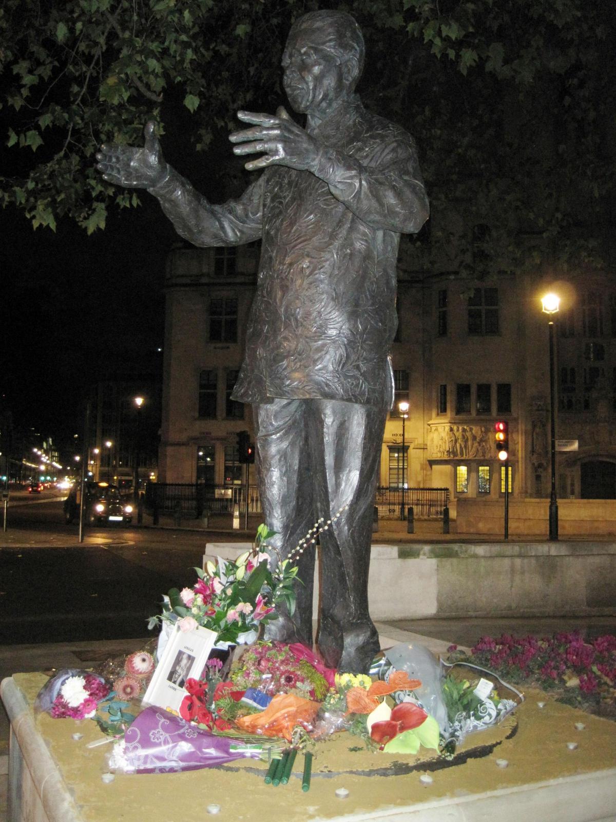 Floral tributes are placed by the statue of Nelson Mandela in parliament Square, central London 