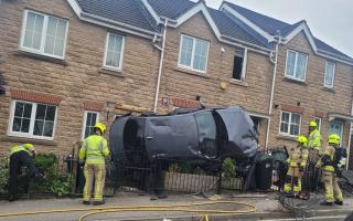 The shocking scene after a car smashed into three homes on Park Lane in Bradford