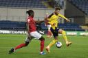 Matty Taylor is held back by Omar Beckles in the first half   Picture: David Fleming