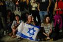 People react as they hear the news of the release of Israeli hostages (AP Photo/Ariel Schalit)