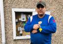 Mr Khan standing next to his meter which was cut by Scottish Power