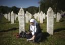 A Bosnian Muslim woman prays at a grave in Memorial Centre, Potocari, earlier this month, as thousands converged on the eastern Bosnian town of Srebrenica to commemorate the genocide which took place in July 1995.