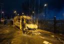 A burnt out police van after a demonstration outside the Suites Hotel in Knowsley, Merseyside, where people were protesting against asylum seekers staying at the hotel.