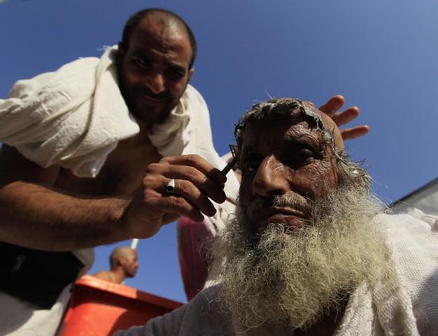 A Muslim pilgrim has his head shaved, after throwing pebbles at a stone
pillar representing the devil, during the Hajj pilgrim in Mina near Mecca,
Saudi Arabia, Tuesday, Nov. 16, 2010.