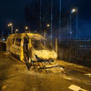 A burnt out police van after a demonstration outside the Suites Hotel in Knowsley, Merseyside, where people were protesting against asylum seekers staying at the hotel.
