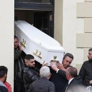 The coffin containing the body of Dlava Mohamed is carried out of the family home in Clones (PA)