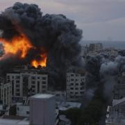Fire and smoke rise from an explosion on a Palestine apartment tower following an Israeli air strike in Gaza City, Saturday, Oct. 7, 2023.