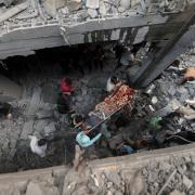 Palestinians evacuate an injured man that was found under the rubble of a destroyed house following an Israeli airstrike in Khan Younis refugee camp, southern Gaza Strip, Saturday, Nov. 18, 2023.